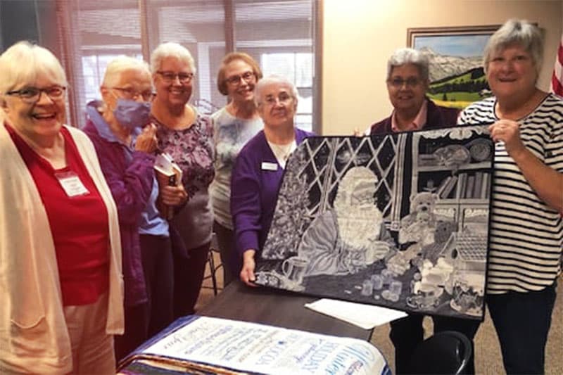 Group of women showing quilt