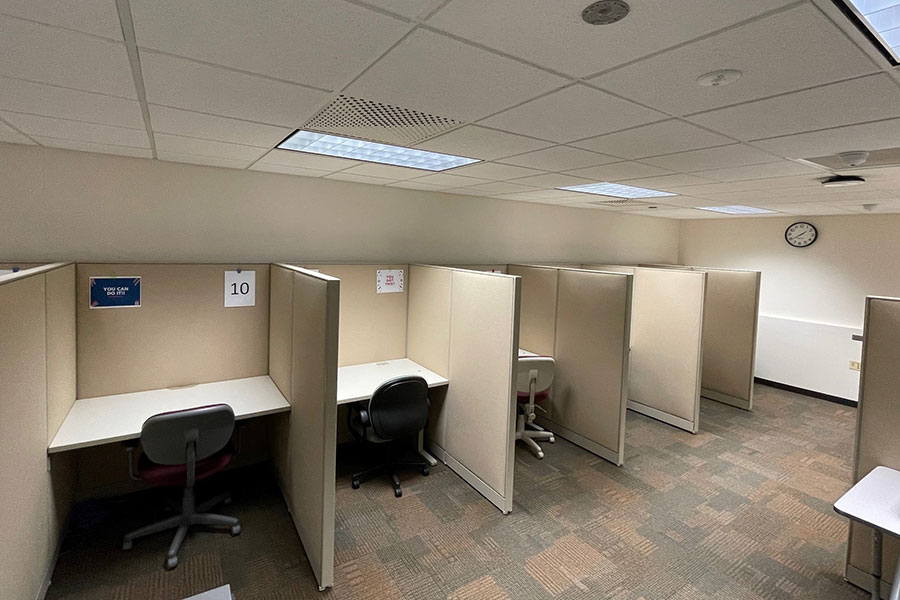 UWGB Testing center is a carpeted space with office chairs and desks with cubicle partitions