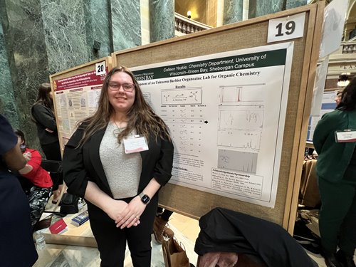 Student standing by project