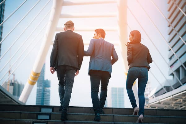 Three professionals walking up stairs
