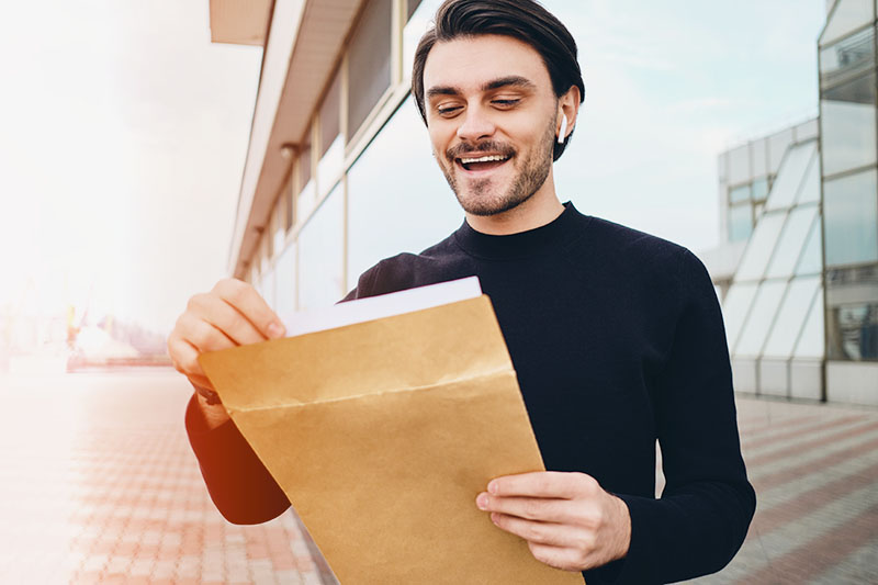 Happy man opening envelope