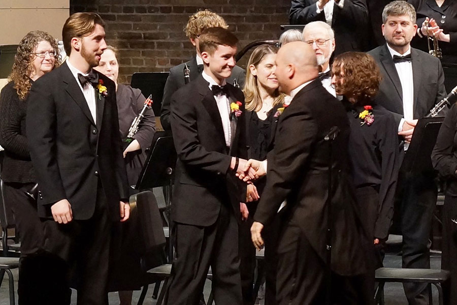Conductor shaking student musicians hand