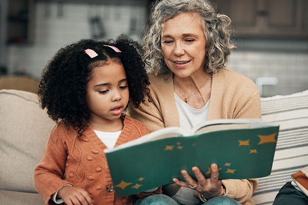 grandmother and granddaughter looking at book