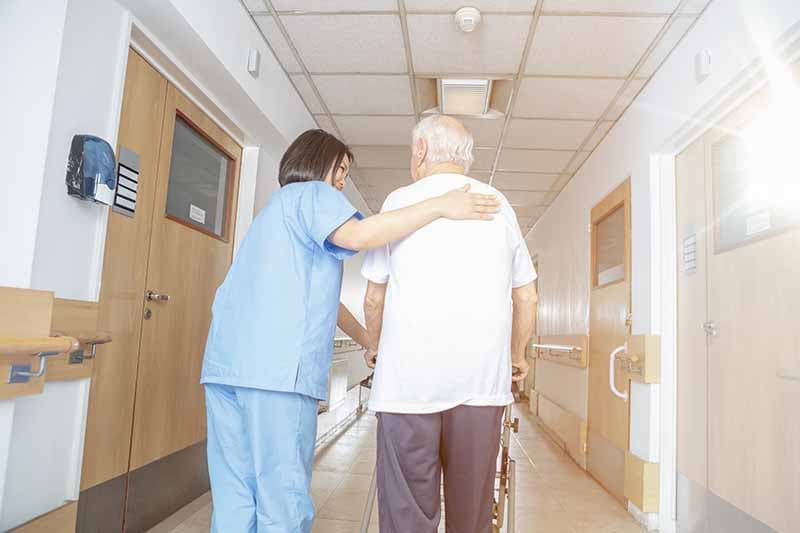 caregiver walking down the hall with resident