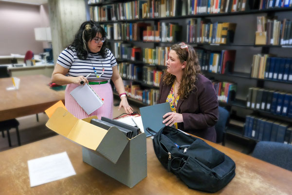 Two students work in library