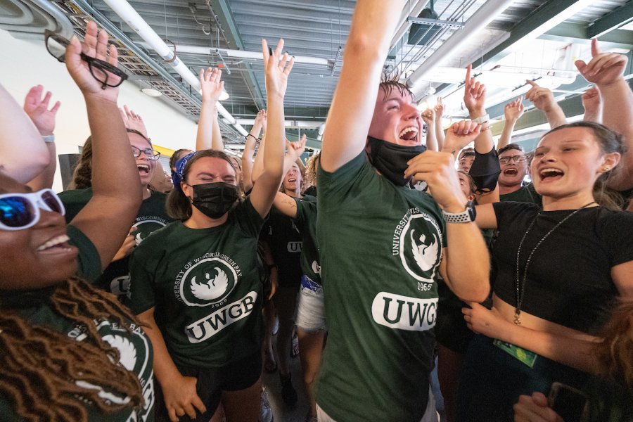 A crowd of students shout and dance to music at the New Student Celebration event at Lambeau Field.