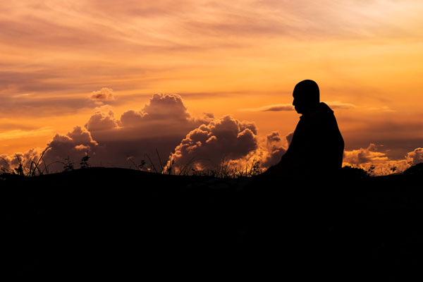 Monk meditating on mountain
