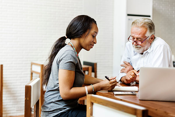 woman caregiver sitting at table with resident