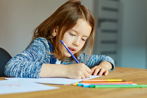 Young girl drawing with colored pencils