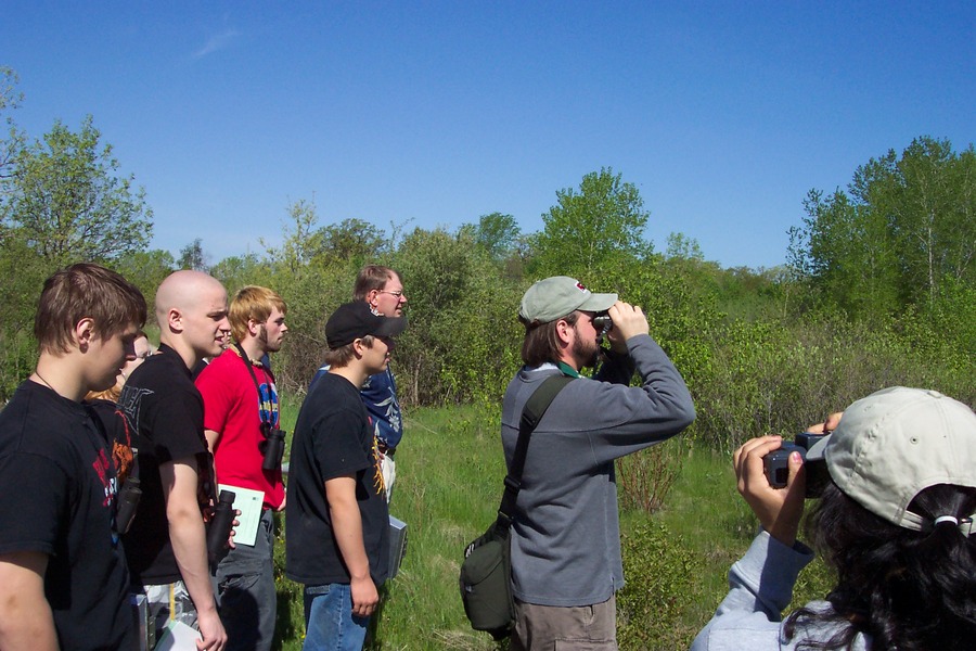 Group of people looking through binoculars in the field